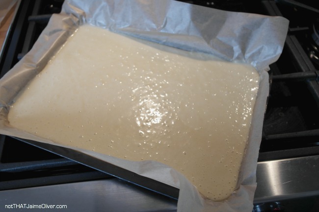 swiss roll mixture in tray going in the oven