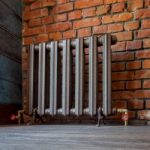 Vintage iron radiator for home with legs. Old cast iron central heating battery.