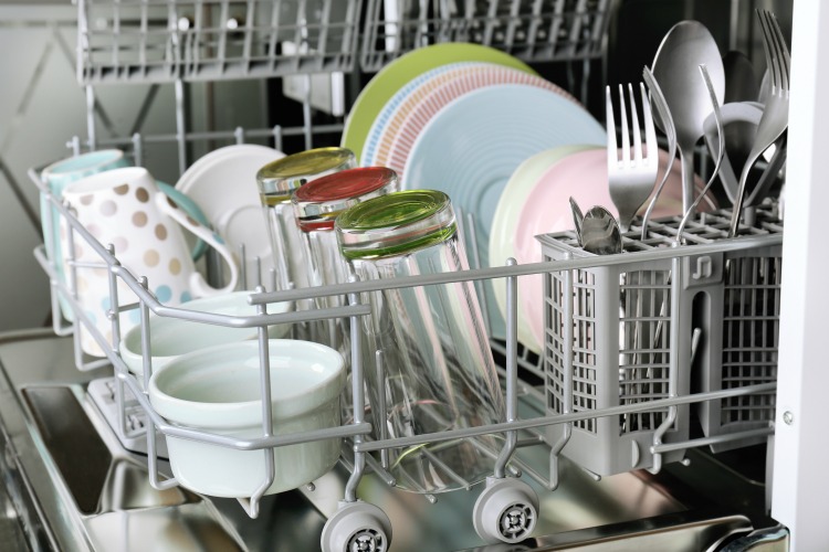 Open dishwasher with clean utensils in it