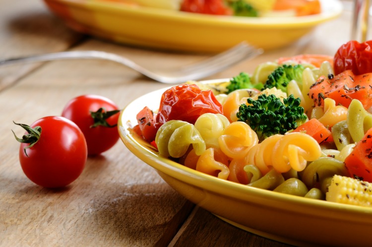 Pasta fusilli salad with broccoli, carrot, corn, and tomatoes on the kitchen table