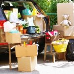 Moving boxes and suitcases in trunk of car, outdoors