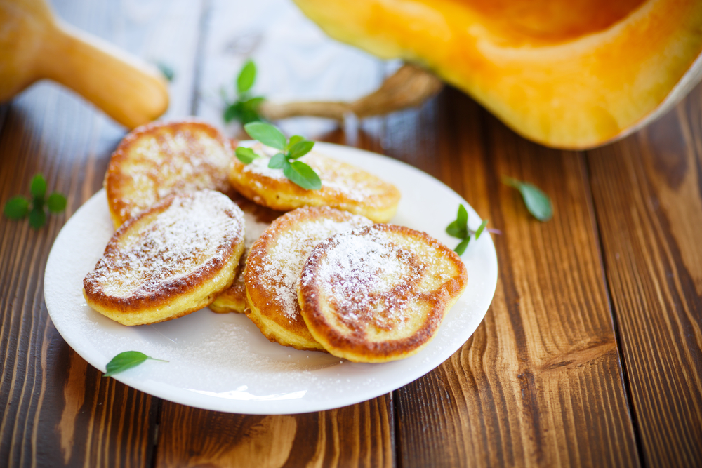 fried sweet pumpkin pancakes on a wooden table