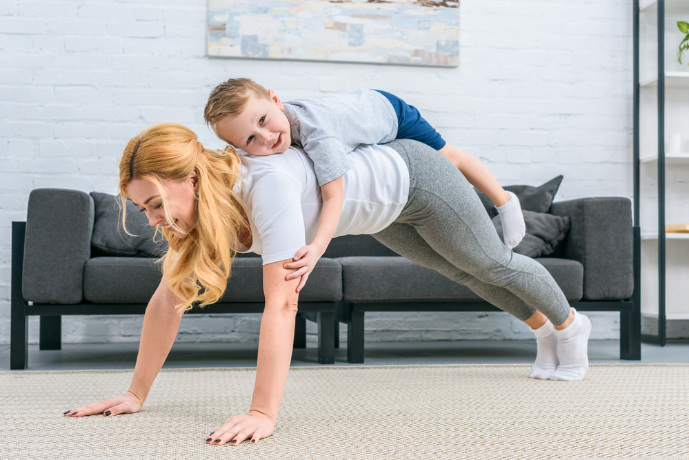 doing a press up with a child on her back